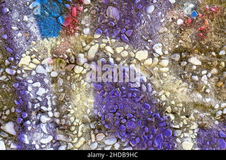 View from above at horizontal picture of colored detail of exposed aggregate concrete with lilac as slightly dominant color. Stock Photo