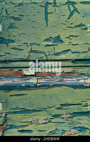 View from above at peeling weathered coatings of two different greens on wood. Vertical. Stock Photo