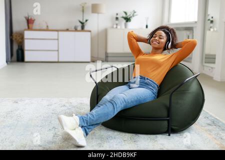 Calm black woman having rest at home on bean bag Stock Photo