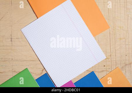 Top view on empty sheet and colored school notebooks on old wooden desk Stock Photo
