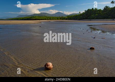 Beach scene in tropical north Queensland during incoming tide with distant approaching thunderstorm Stock Photo