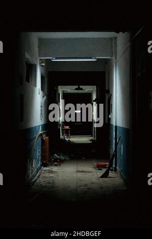Vertical shot of hallway in an old, abandoned, and dark hospital Stock Photo