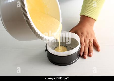Pour Cake  Mixture to the Prepared Round Baking Pan with Baking Paper. Step by Step Baking On Bakery Concept, White Background Stock Photo