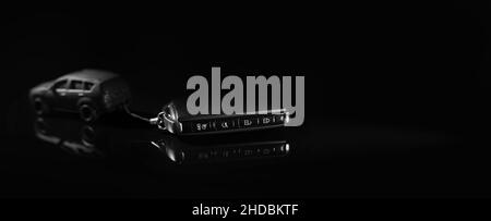 car model pulls remote key on black background. buy new car concept. banner copy space Stock Photo