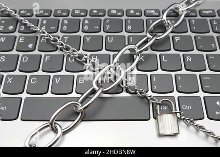 A computer keyboard with a chain and a padlock, cybersecurity concept Stock Photo