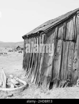 Black and white high key rendition of crooked, decaying home, Bodie State Park, on a cloudless day and plenty of copy-space. Bodie is a California gol Stock Photo