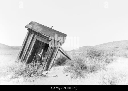 Black and white high key rendition of tilted tools shed at Bodie State Park, on a cloudless day and plenty of copy-space. Bodie is a California gold m Stock Photo