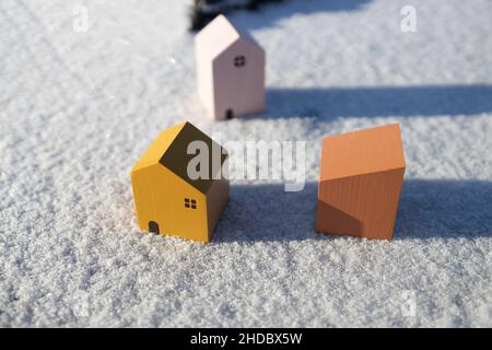 Winter landscape with miniature model of wooden houses on winter snow background. Home, loan, money investment concept. Stock Photo