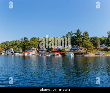 Shoreline houses, properties and moorings at Alton Bay, Lake Winnipesaukee, Alton, New Hampshire, New England, USA on a sunny day with blue sky