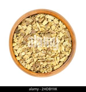 Liquorice root  chips, in a wooden bowl. Dried, cut root of licorice, Glycyrrhiza glabra. Used as tea, or as sweet extract for flavouring candies. Stock Photo