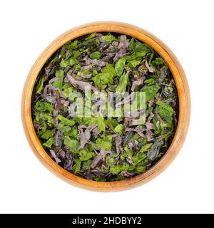 Seaweed flakes in a wooden bowl. Mix of dulse (Palmaria palmata), sea lettuce (Ulva lactuca) and nori. Dried marine algae, rich in natural iodine.