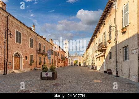 Cherasco, Cuneo, Italy - October 27, 2021: via Vittorio Emanuele II with the historic buildings and Arch of Belvedere in the background, main street o Stock Photo
