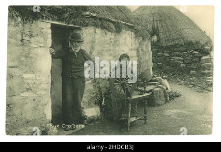 Original early 1900's Edwardian era postcard of Skye crofters, tenant farmers, outside their croft, the old woman has a spinning wheel and is spinning wool - subsistence living. Printed by the Reliable series by W R & S William Ritchie and sons - circa 1905. Isle of Skye, Inner Hebrides, Scotland, U.K.