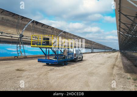 Maintenance team cleaning the panels of a solar thermal power plant. Stock Photo