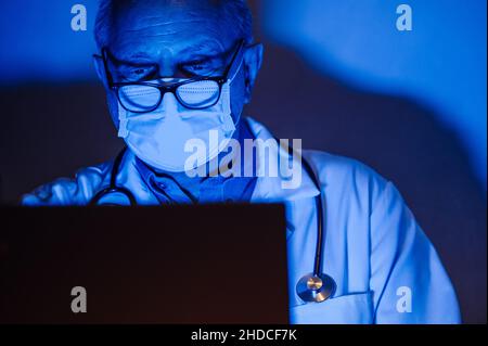 Doctor working on his computer late in the evening Stock Photo