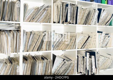 Shelves are full with folders and files of medical record, patient information Stock Photo
