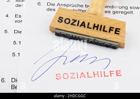 Holzstempel, Formulare im Hintergrund, Aufschrift: Sozialhilfe Stock Photo