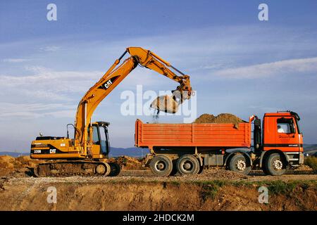 Bagger und LKW bei Erdarbeiten, Bagger belädt LKW mit abgetragener Erde, Stock Photo