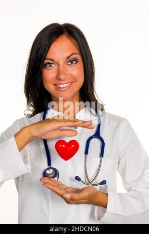 Eine junge Ärztin (Internistin) hält ein Herz symbolisch in der Hand.