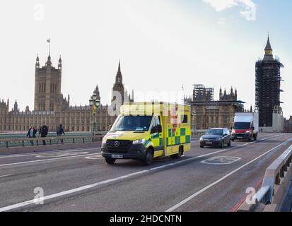 An ambulance passes by the Houses of Parliament on Westminster Bridge during the coronavirus pandemic. London, United Kingdom 18 February 2021. Stock Photo