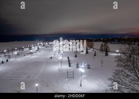 Strelka's place in Yaroslavl - a park and a stele in it. People walking in the distance. Stunning night view of the Golden Ring city around Moscow Stock Photo