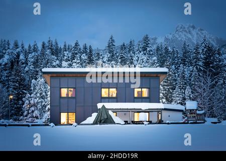 Frontal view of a single-family house with a solar thermal facade for sustainable and renewable heating and hot water energy at night in winter Stock Photo