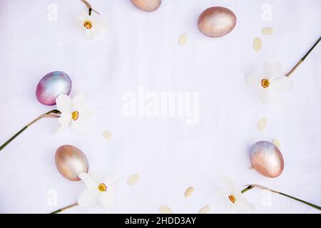 Easter background. Veri peri and orange multicolored eggs and narcissus flowers. Top view, copy space. High quality photo Stock Photo