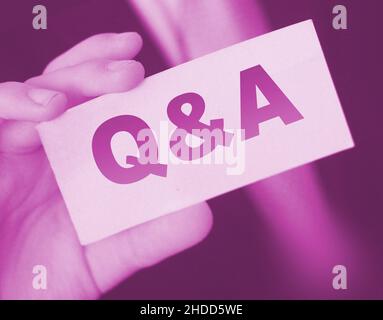 Q and A Questions and Answers sign on business card shown by a businessman,. Business concept. Stock Photo