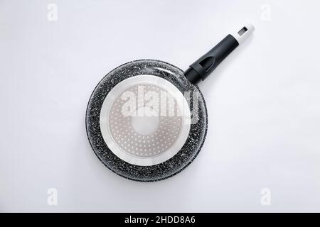 Back view of black marble frying pan on light grey background, top view Stock Photo