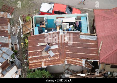 03/01/2022 Cebu City, Philippines. A man fixing the roof of his house severely damaged by Typhoon Odette (International name Rai) which struck the Vis Stock Photo