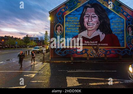 Children passing the Bobby Sands mural in ,Belfast , Northern Irland.He is the symbol of war between catholic and protestant