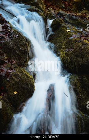 A vertical shot of the motion of a waterfall falling heavily from a ...