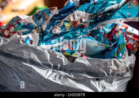 Discarded used wrapping paper in a trash bag after opening gifts . Stock Photo