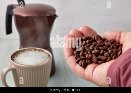 Freshly roasted coffee beans on a tired male palm Stock Photo