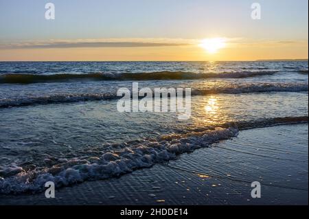 Reflection of sunlight in the sea waves. The sky in the sunset rays. Baltic Sea. Sunset over the sea. Stock Photo