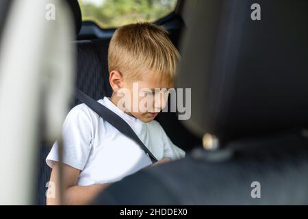 Little boy buckled up with seatbelt inside the car. Vehicle and ...