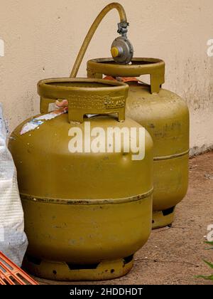 Two golden cooking gas cylinders outside the house Stock Photo