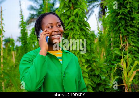 beautiful african lady making calls in the farm Stock Photo