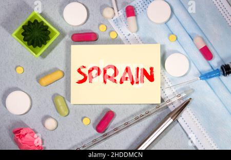 Medicine concept. On a reflective white surface lies a stethoscope and cubes with the inscription - SPRAIN Stock Photo