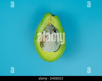 top view of half avocado on blue background. healthy fruit concept. Stock Photo