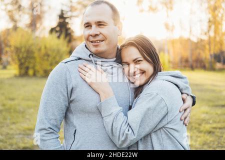 Close-up portrait of a smiling middle-aged couple posing in the park. Stock Photo