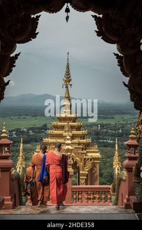 Lampang, Thailand - Sep 04, 2019 : Buddhist Monks are walking into down the gate of Wat Phra That Doi Phra Chan in Lampang. A temple on the top of a m Stock Photo