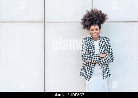 Afro-haired businesswoman posing facing the camera smiling. Stock Photo