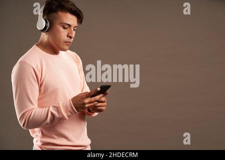 latin man headphones looking cell phone listening music Stock Photo