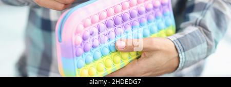 Woman is unbuttoning bright pops it pencil case Stock Photo