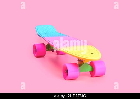 rainbow plastic Penny board skateboard isolated on pink background Stock Photo