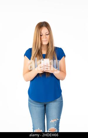 Young woman on a white background looking at the smartphone. Stock Photo