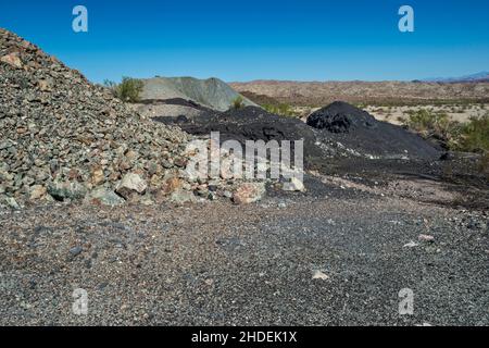 Waste rock (grey), slag (black) tailings near copper smelter at Swansea copper mining townsite, Buckskin Mountains, Sonoran Desert, Arizona, USA Stock Photo