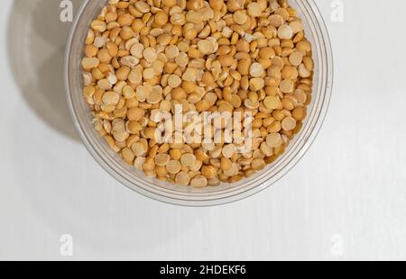 Pea halves in plastic cup on white table. Top view Stock Photo