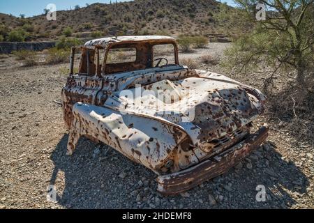Old pick up truck wreck, riddled with bullet holes, at Swansea copper mining townsite, Buckskin Mountains, Sonoran Desert, Arizona, USA Stock Photo